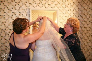 I love this picture of The Vintage Modern Wife, her mom, and her mother in law helping put her veil on before her wedding. I need a picture like this!